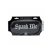 Black satin blindfold with 'Spank Me' branding in packaging on a white background