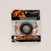 A black textured OXBALLS brand squishy ring in its original retail packaging, featuring a black and orange header card with product text.