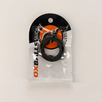 A black OX Balls silicone ring accessory in its original clear plastic packaging with a black and orange header card, photographed on a plain white background.