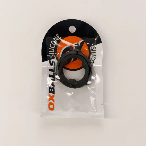 A black OX Balls silicone ring accessory in its original clear plastic packaging with a black and orange header card, photographed on a plain white background.