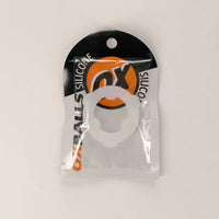 A white circular silicone ring accessory in a clear plastic blister pack with a black and orange header card. The packaging features the text 'OX SILICONE' and 'OX BALLS'.