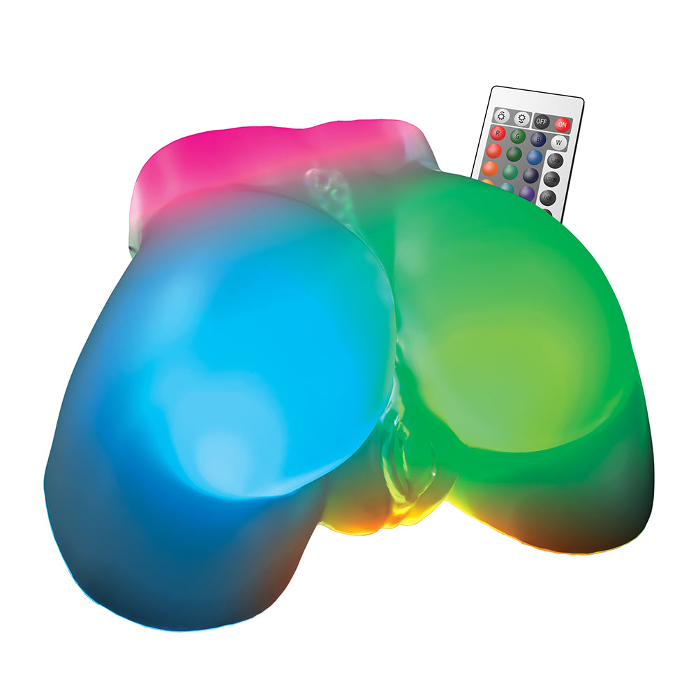 A novelty light-up silicone product with two bulb-like sections glowing in blue and green, plus a small remote control on a plain white background.