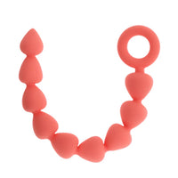 peach silicone anal beads with finger ring on a white background