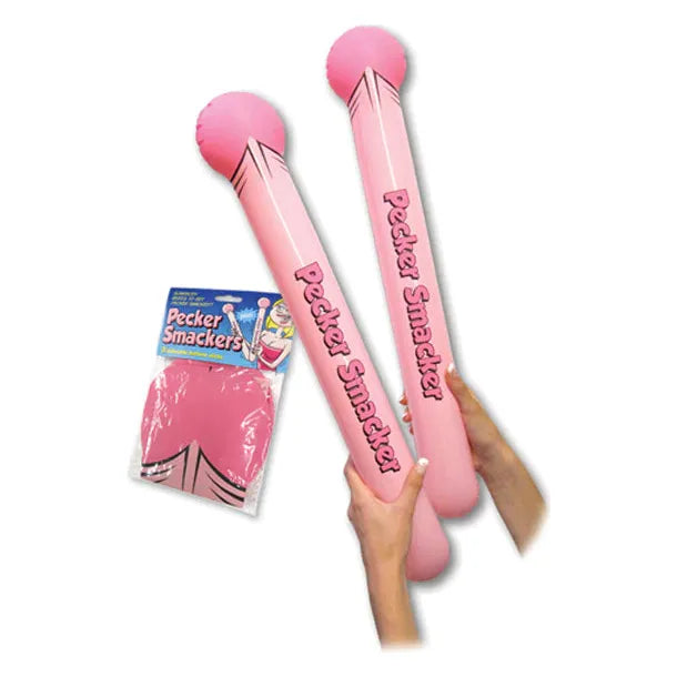 Two inflatable pink inflatable penis's with text on them, held by a person, with packaging visible in the background.