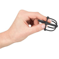 hand holding penis plug with glans cage, on white back ground