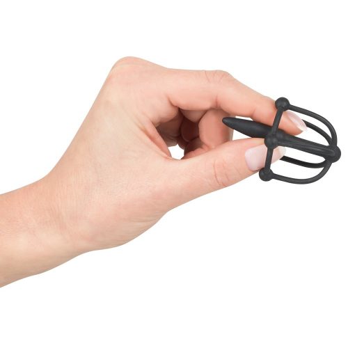 hand holding penis plug with glans cage, on white back ground