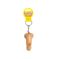Beige penis whistle keychain on a white background with a yellow packaging label.