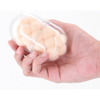 Hand holding a transparent container with a masturbator on a white background