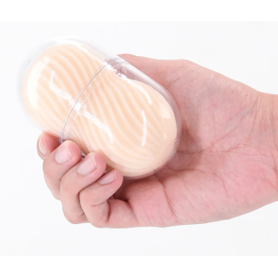 Hand holding a clear plastic container with a beige masturbator  inside on a white background