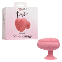 pink heart shaped finger massager with tiny bristles on the top, suction cup bottom, beside box packaging