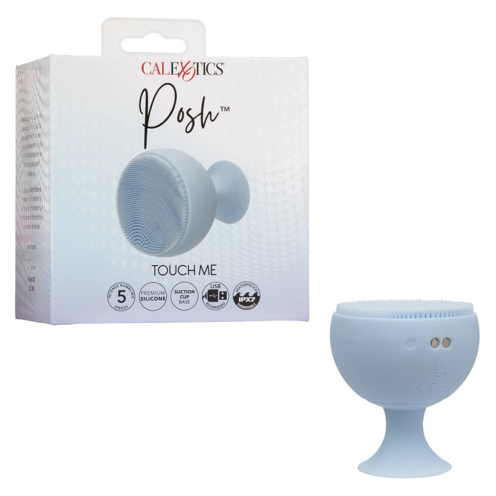 finger massager in the shape of a cup with tiny bristles on the top, suction cup base, beside box packaging