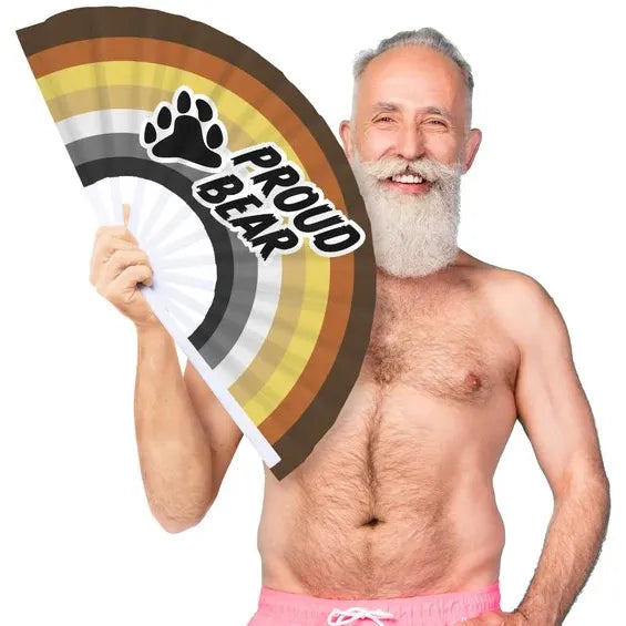 Man holding a 'Proud Bear' rainbow flag on a white background