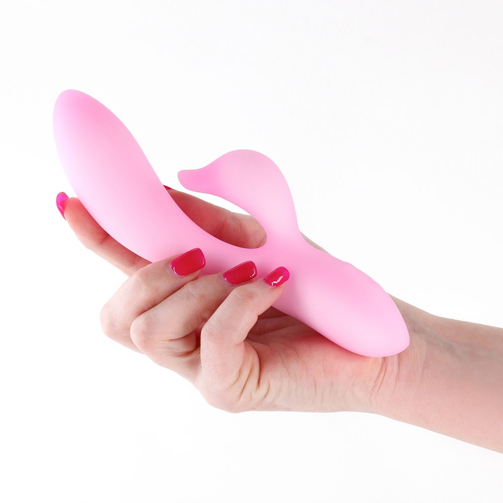 Pink vibrator held in a hand with red nail polish on a white background