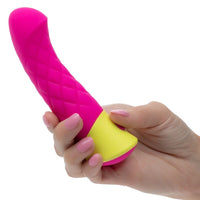 Pink and yellow rave quilted g vibrator held by a hand on a white background