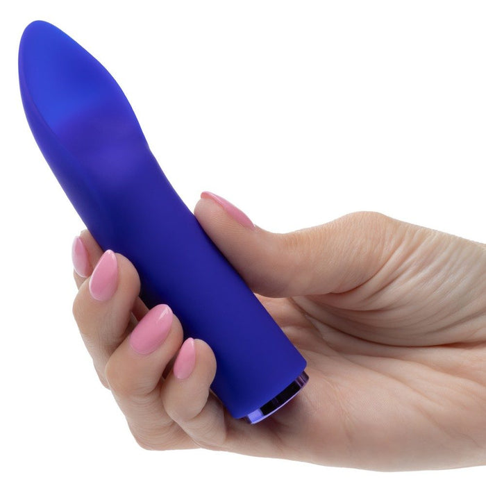 Hand holding a purple raven flutter vibrator against a white background