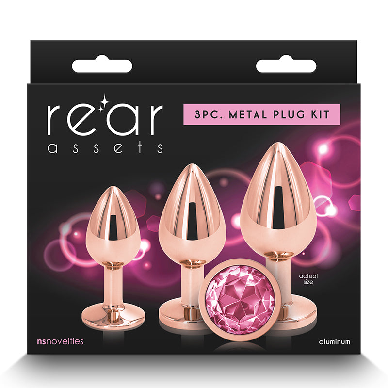 The image features the "Rear Assets Aluminum Metal Anal Plug Kit Circle 3pk by NS Novelties," a set of three anal plugs packaged for retail sale. The plugs are crafted from lightweight aluminum with a chrome-plated finish, adding a touch of elegance and sophistication.