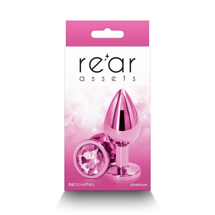 The product image shows a pink and silver anal plug in its packaging, with the brand 'Rear Assets' displayed. The plug has a smooth, chrome-plated finish and a tapered shape for easy insertion.