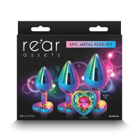 The image shows a 3-piece metal plug kit with a gradient of blue to green and a chrome-plated finish. The plugs are displayed in different sizes, with the smallest having a heart-shaped base, and the set is packaged in a black box with the brand 'Rear Assets' prominently shown.