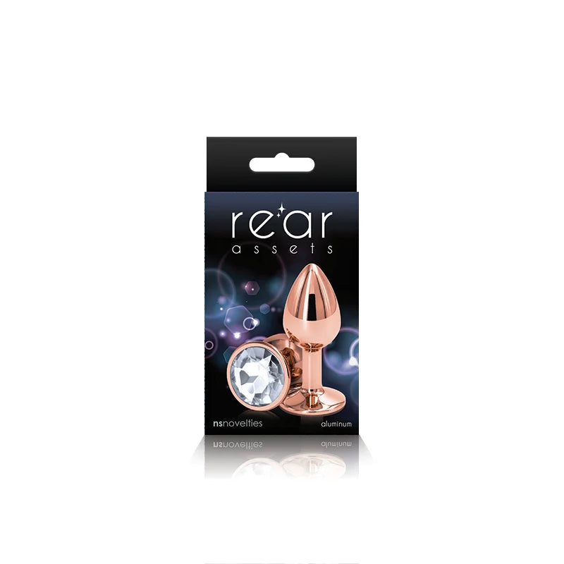 The product image shows a small, chrome-plated anal plug with a pointed tip and a circular base, packaged in a black box with purple and pink accents. The box features the brand name 'Rear Assets' prominently displayed.