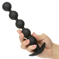 Black power balls held in a hand against a white background