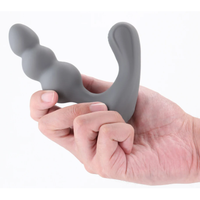 Gray silicone butt plug held in a hand against a white background
