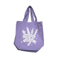 Purple tote bag with i still play with toys in white text and graphics on a white background