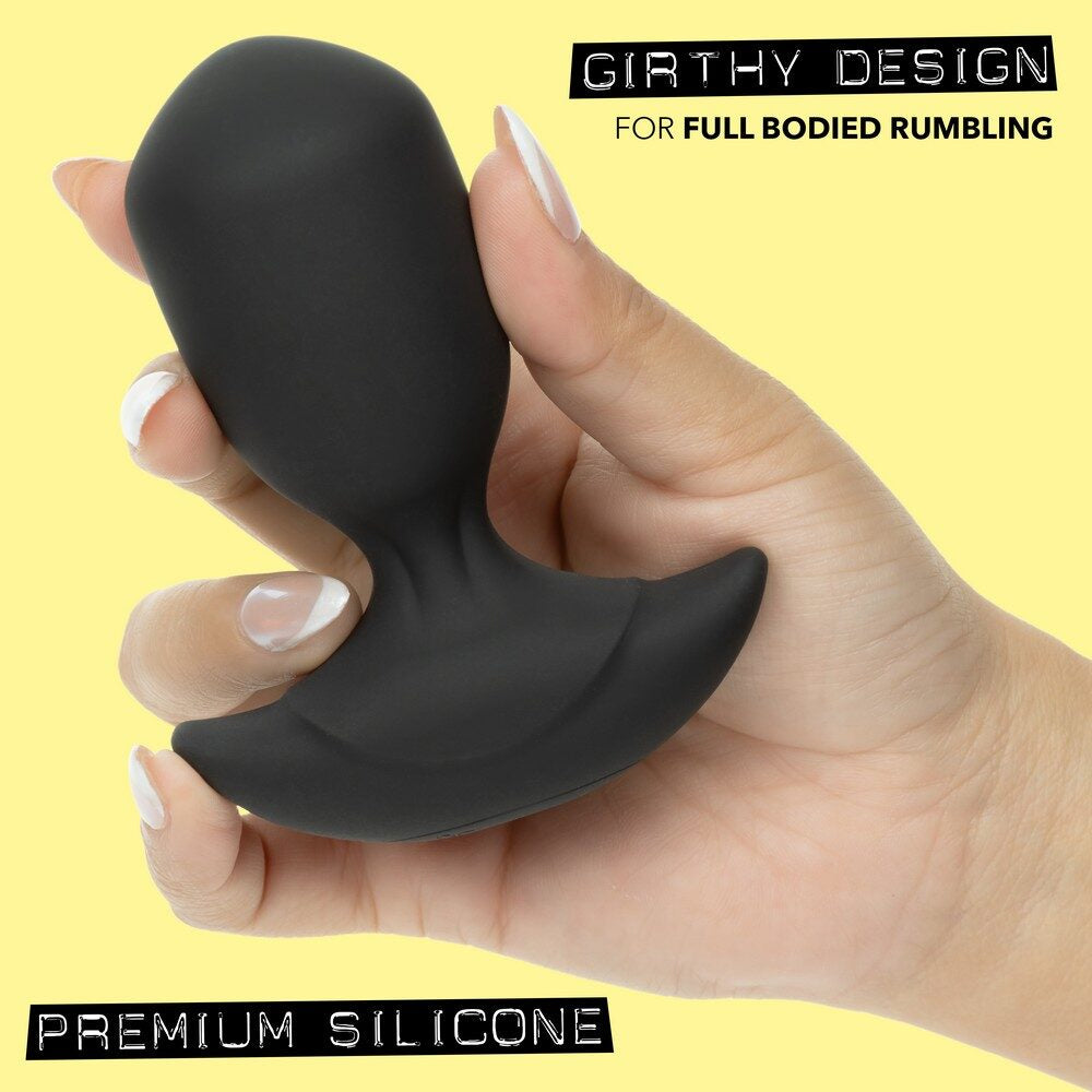 Hand holding a black silicone anal probe with 'Girthy Design' text on a yellow background
