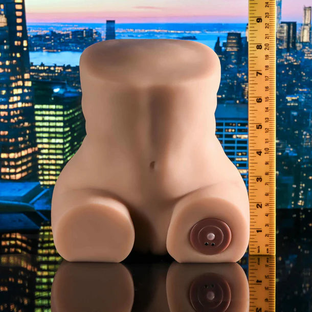 Silicone mold shaped like a torso with a ruler for scale against a cityscape background