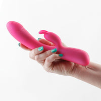 Hand holding a pink vibrator with a white background