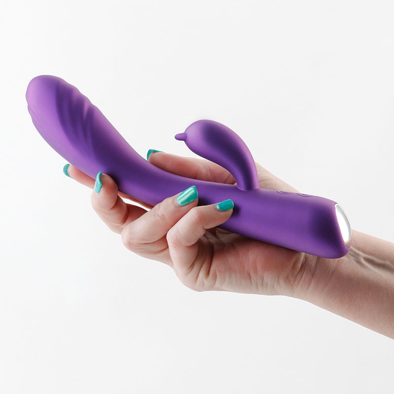 Hand holding a purple duchess vibrator against a white background