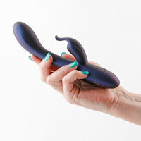 Hand holding a navy empress vibrator curved object against a white background