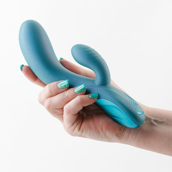 Hand holding a teal regent vibrator against a white background