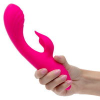 Pink rumbler rumble duo vibrator held by a hand on a white background