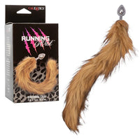 Brown fur tail with anal plug on a white background, next to its packaging labeled 'Running Wild'.