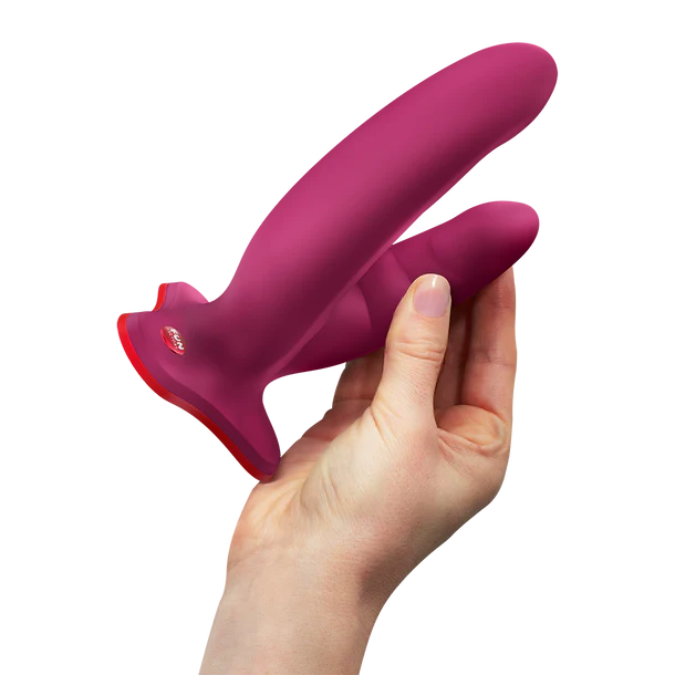 Hand holding a pink and red silicone dildo against a white background