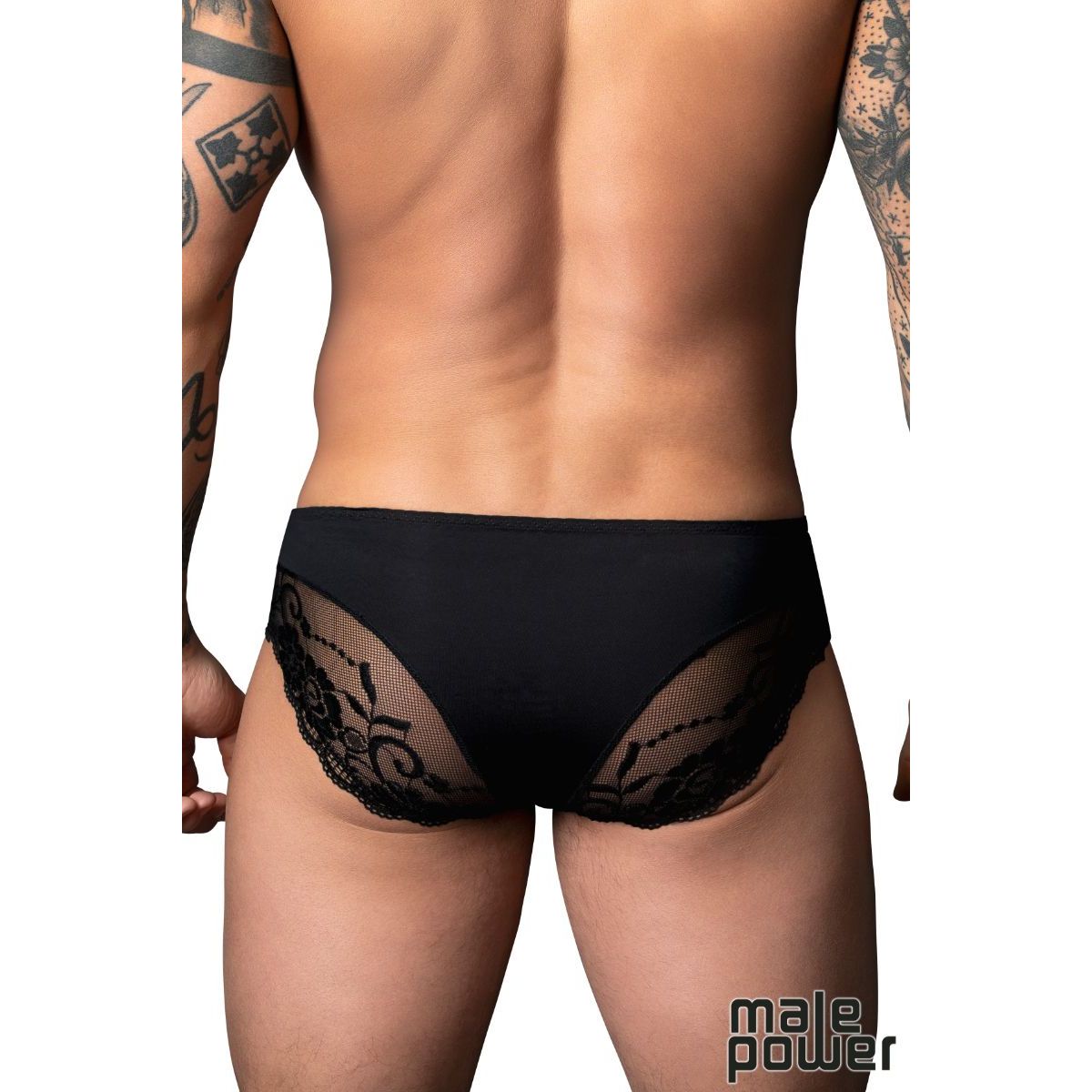 Black lace underwear worn by a person with tattoos on a white background