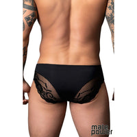 Black lace underwear worn by a person with tattoos on a white background