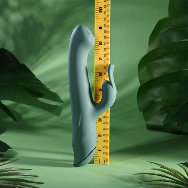 Green vibrator with a yellow ruler against a green leafy background