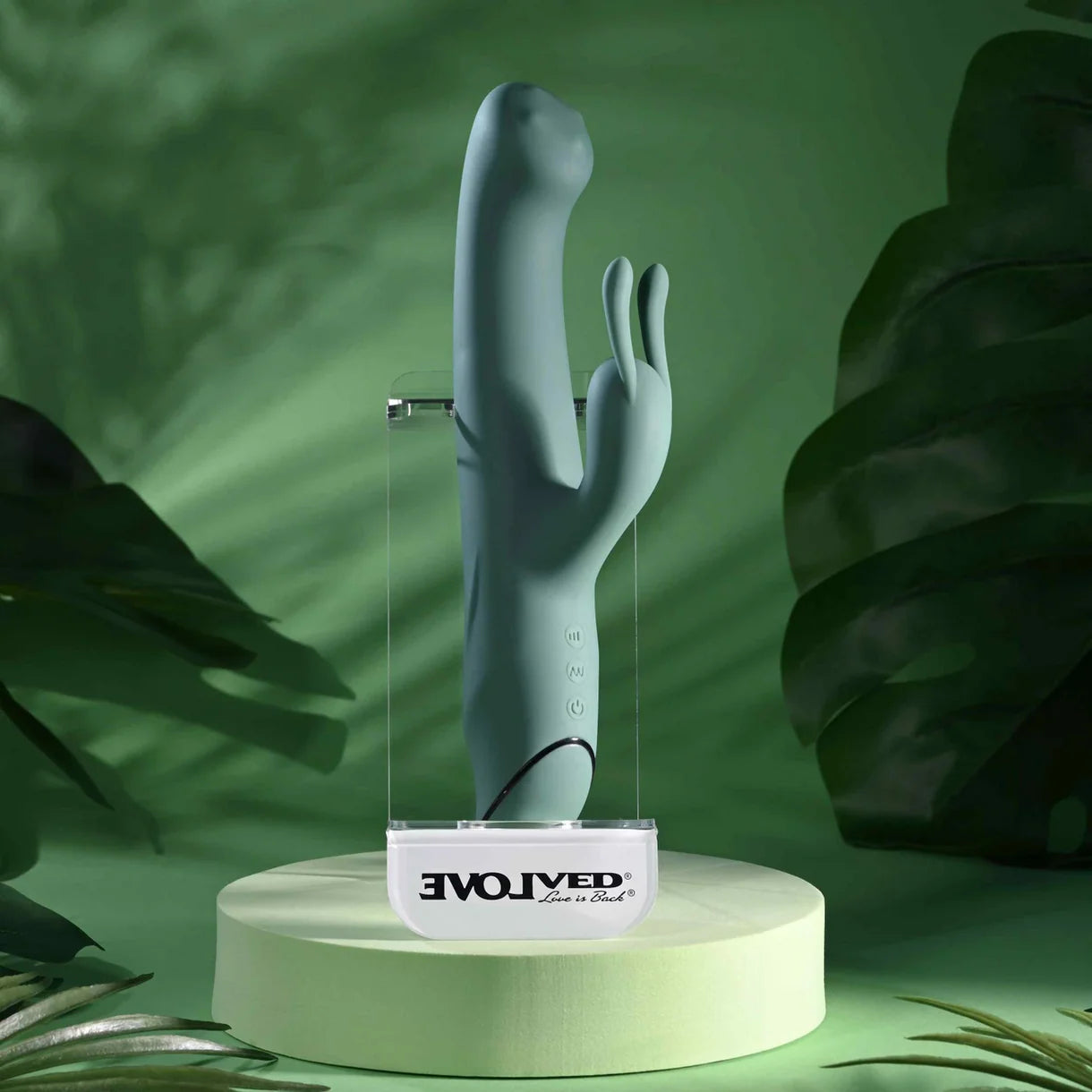 Silicone vibrator on a stand with 'EvolvEd' branding against a green leafy background