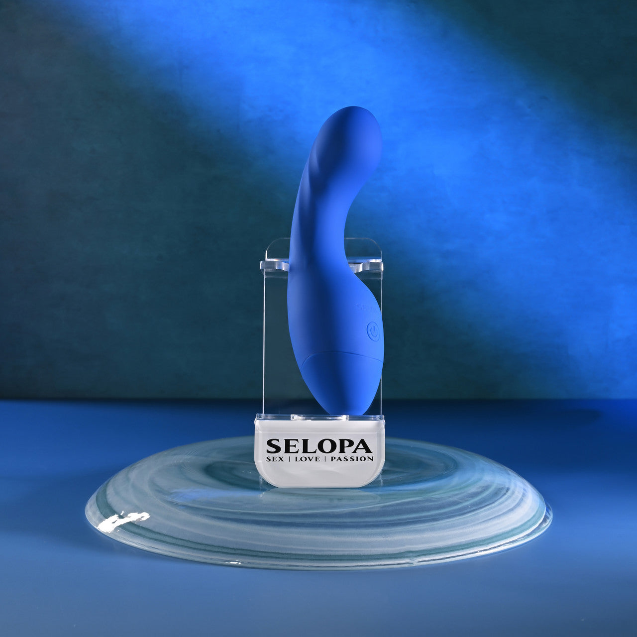 blue g spot vibrator with thicker bottom, on stand, on blue background