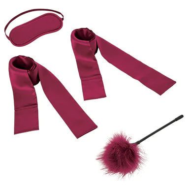 a burgundy kit that includes a feather tickler, a blindfold and two tie up sashes
