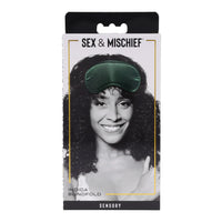 Packaging of a green sleep mask with a woman's face on it, branded 'Sex & Mischief'.