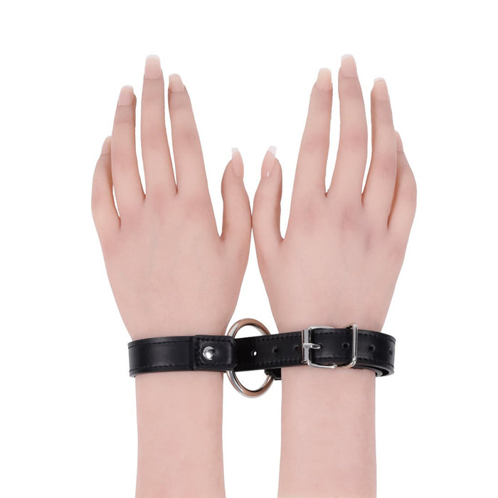 Black leather collar cuffs with a ring on a white background
