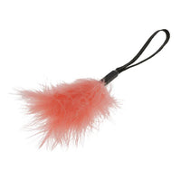 Peach feathered wrist tickler with a black string on a white background
