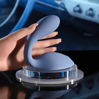 Blue grinder vibrator with a hand holding it against a blurred background