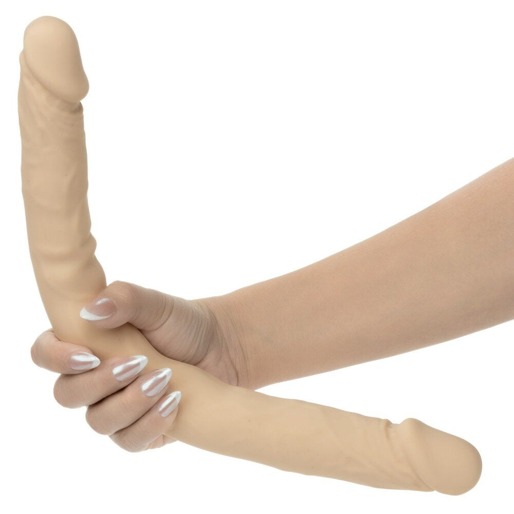 Beige silicone double dildo on a hand against a white background
