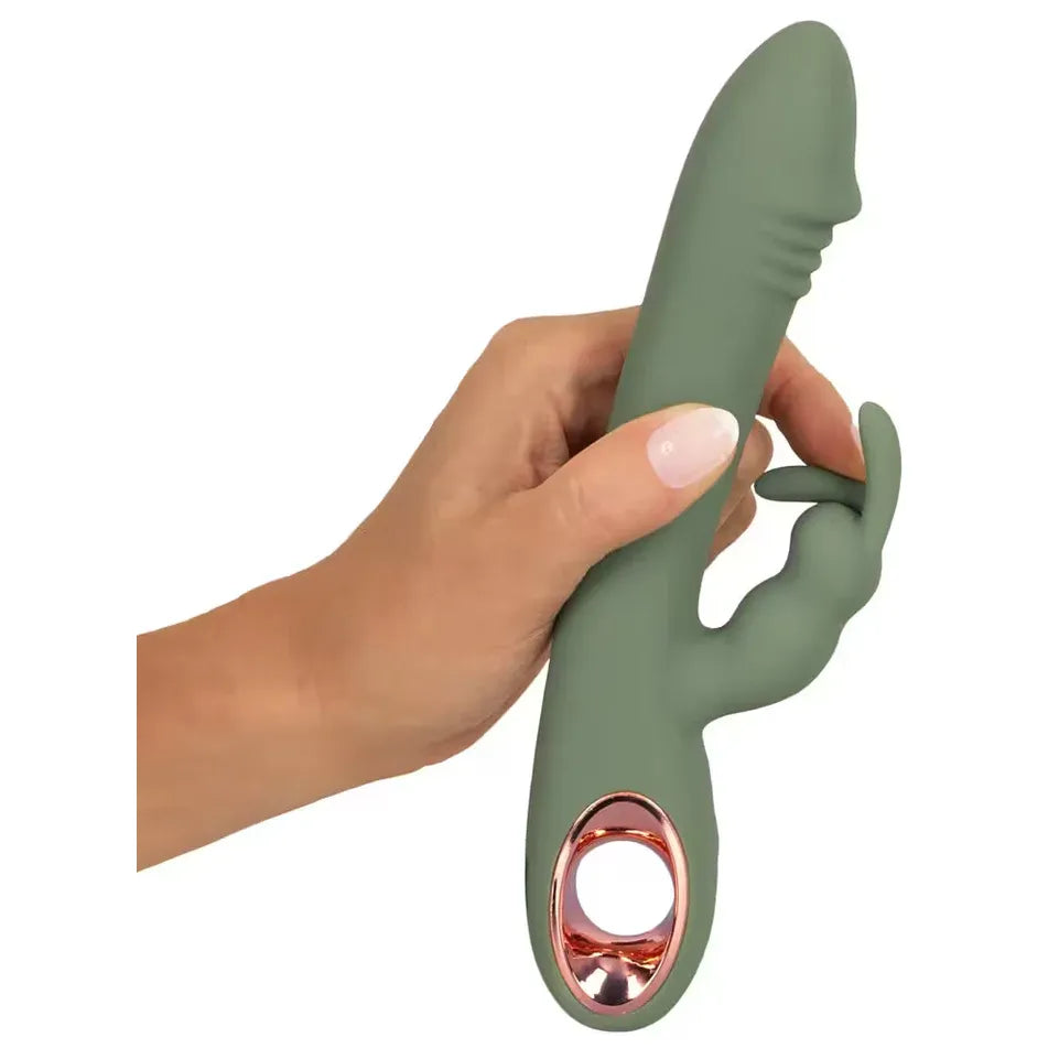 Hand holding a green and rose gold rabbit vibrator against a white background