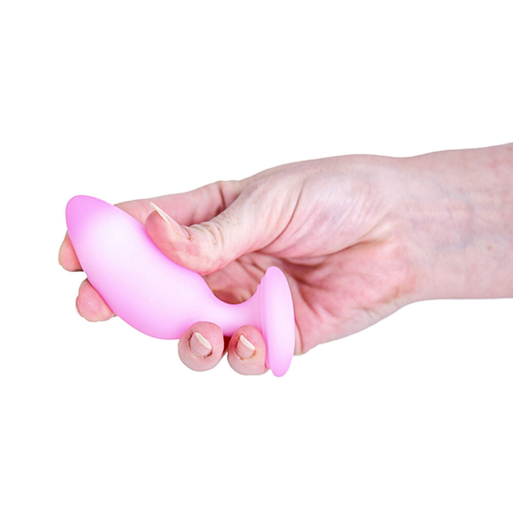 Hand holding a pink silicone anal plug against a white background