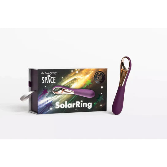 a purple vibrator with gold accents and a finger ring at the base shown next to its space themed display box