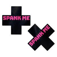 black cross pasties with spank me written in pink letters